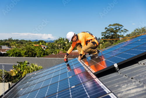 Solar panel technician with drill installing solar panels