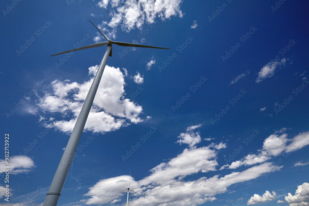 Elektrownia wiatrowa - wiatrak na tle błękitnego nieba z chmurami