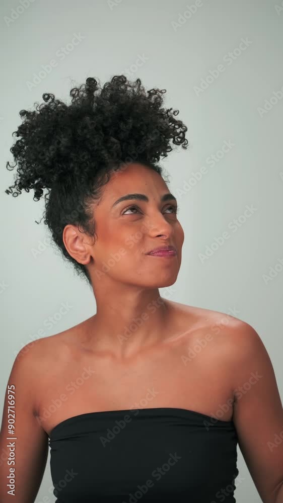 Portrait of a young swarthy woman with curly black hair and bright makeup. She smiles and laughs. Portrait of a young swarthy woman with curly black hair and bright makeup. She smiles and laughs.