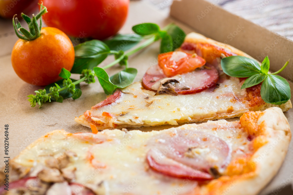 cooked pizza with salami and sausage in a box on a wooden table cooked pizza with salami and sausage in a box on a wooden table