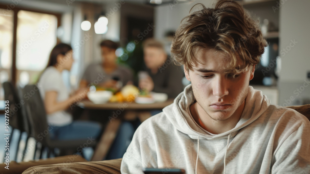 Sad teenage boy scrolling his phone, Behind him, happy family is eating dinner at the table. Generative ai Sad teenage boy scrolling his phone, Behind him, happy family is eating dinner at the table. Generative ai