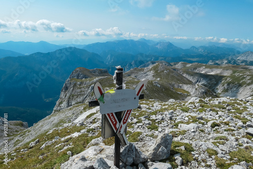 Summit cross of mountain peak Zagelkogel in Hochschwab massif, Styria, Austria. Idyllic hiking trail on alpine terrain, remote Austrian Alps in summer. Sense of escape. Panoramic view of rugged ridges photo