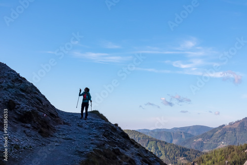 Hiker woman with panoramic view of untamed Hochschwab mountain region, Styria, Austria. Scenic hiking trail to majestic mountain peak Foelzkogel in remote Austrian Alps. Wanderlust in alpine summer photo