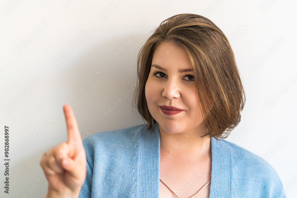 Plus-size woman making warning gesture with index finger, expressing caution and attention. Advice, attention, and warning concepts. Plus-size woman making warning gesture with index finger, expressing caution and attention. Advice, attention, and warning concepts.