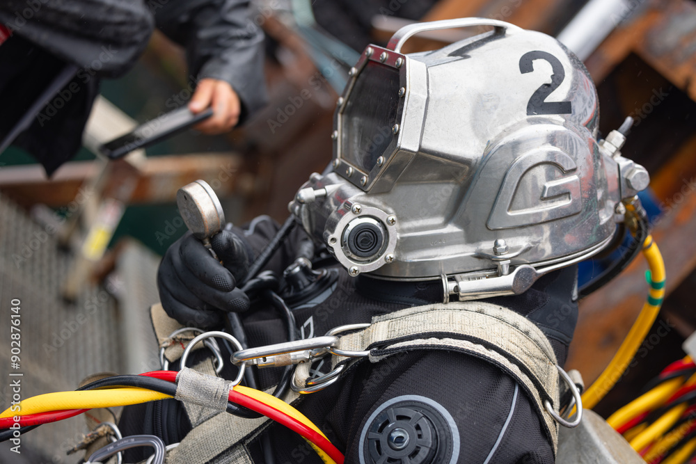 Obraz premium Commercial diver in helmet prepares for dive