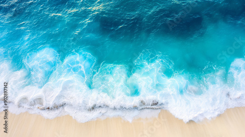 Aerial view of waves crashing on a sandy beach.