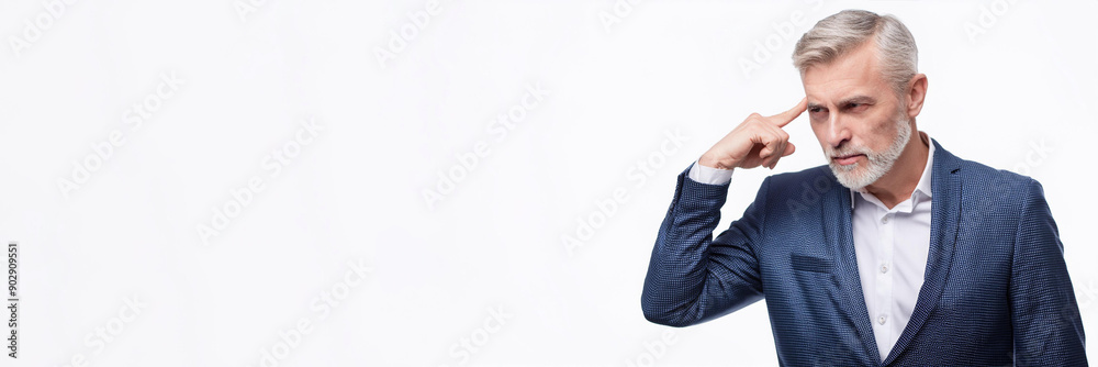 Close-up portrait of a senior businessman gesturing with his finger against his temple, as if to say, Close-up portrait of a senior businessman gesturing with his finger against his temple, as if to say,