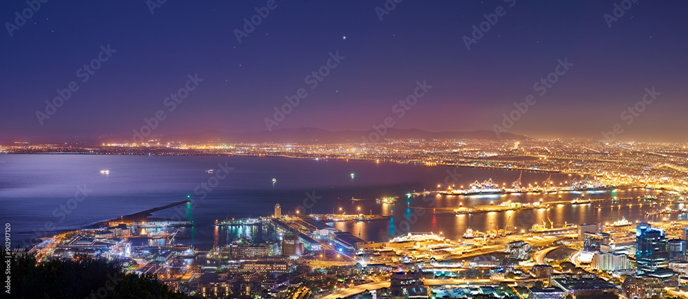Fototapeta premium Night, urban and buildings or cityscape and ocean for travel, skyline and development. Architecture, skyscraper and hospitality or outdoor with horizon or landscape for business and nature or hotel