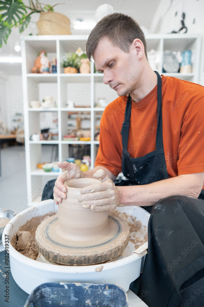 A potter works on a potter's wheel to smooth the surface of a vase. A potter works on a potter's wheel to smooth the surface of a vase.