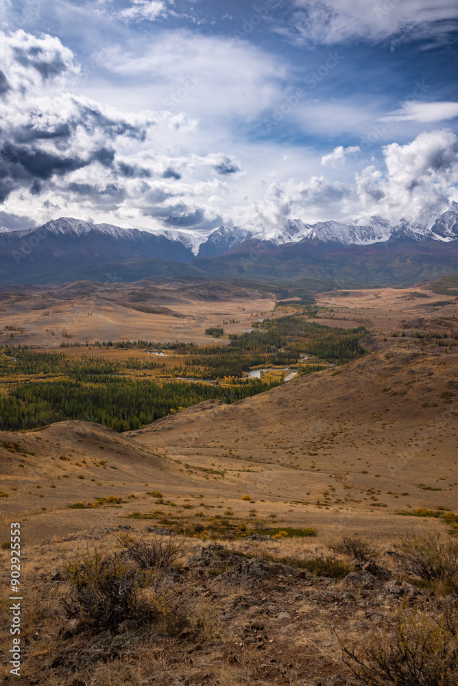 Breathtaking view of a vast mountain valley with snowcapped peaks under a dramatic sky, showcasing nature grandeur. Breathtaking view of a vast mountain valley with snowcapped peaks under a dramatic sky, showcasing nature grandeur.