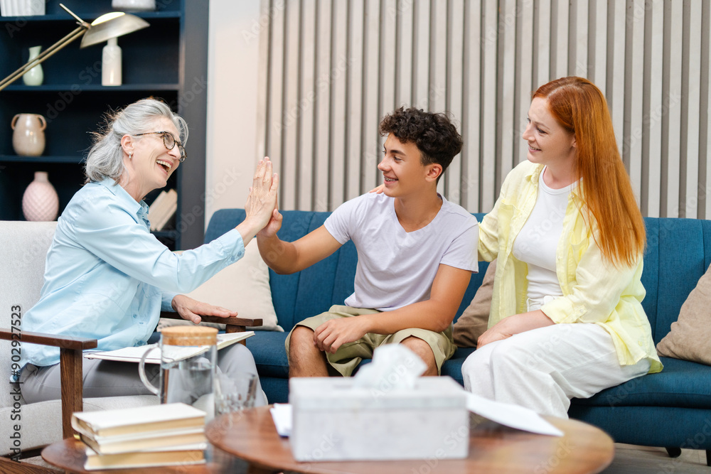 Happy family giving high five to therapist celebrating success during therapy session Happy family giving high five to therapist celebrating success during therapy session