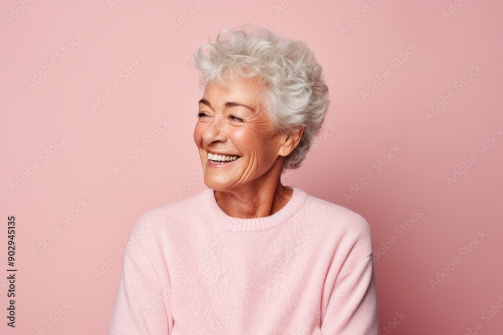 Portrait of a smiling elderly 100 year old woman dressed in a comfy fleece pullover on pastel pink background Portrait of a smiling elderly 100 year old woman dressed in a comfy fleece pullover on pastel pink background