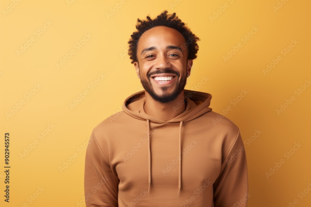 Portrait of a smiling man in his 30s wearing a thermal fleece pullover on pastel yellow background Portrait of a smiling man in his 30s wearing a thermal fleece pullover on pastel yellow background