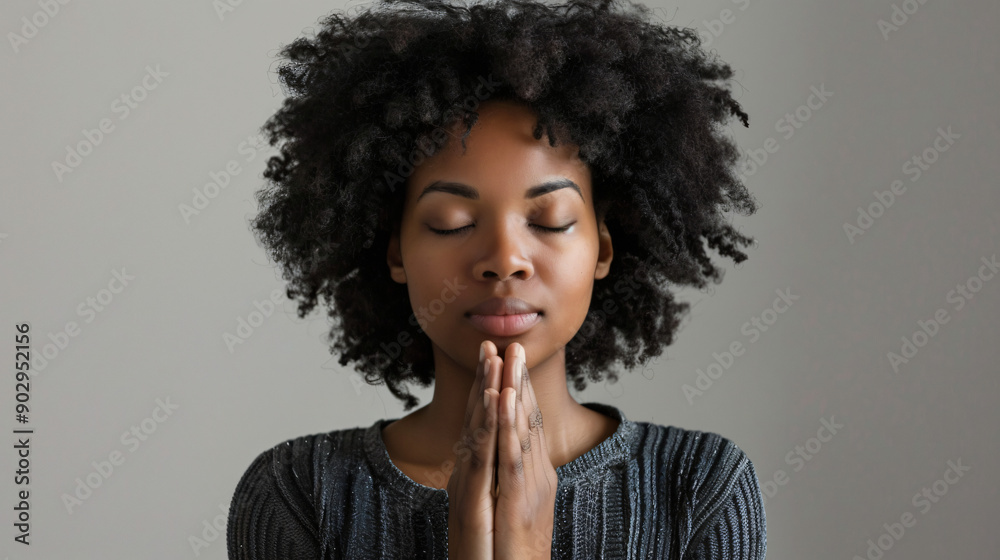 Young woman with serene expression and folded hands in prayer, conveying spirituality and calmness Young woman with serene expression and folded hands in prayer, conveying spirituality and calmness