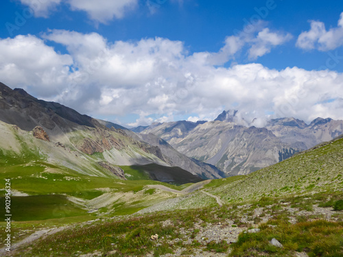 Obraz na płótnie Alpine green pasture with panoramic view of mountains and hills in valley Valle Stura in Colle Del Puriac, Piemonte, Italy, Europe. Hiking tour in Italian Alps in summer. Peaceful serene atmosphere w salonie