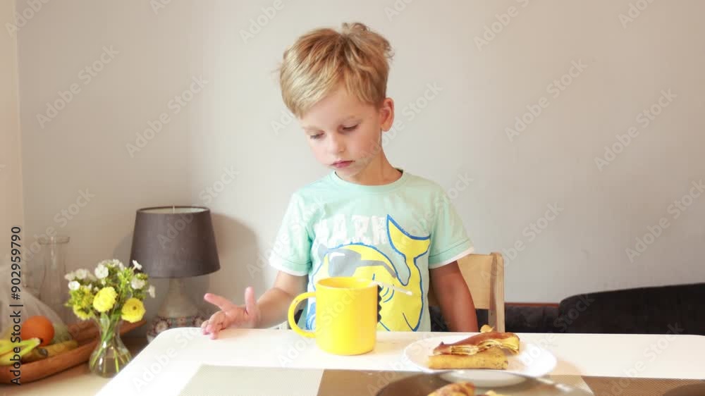 Caucasian Boy Enjoys Breakfast in the Kitchen While Contemplating His Day Ahead Caucasian Boy Enjoys Breakfast in the Kitchen While Contemplating His Day Ahead