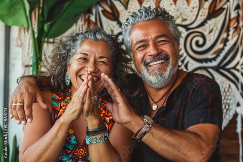 Portrait of a grinning latino couple in their 50s joining palms in a gesture of gratitude photo