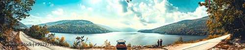 A car parked at a highway overlook, with people taking photos and enjoying the view