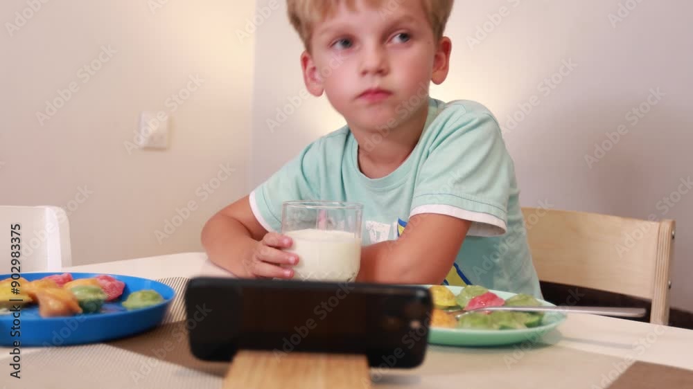 Caucasian Boy Eating Healthy Fruits and Drinking Milk in Kitchen at Home