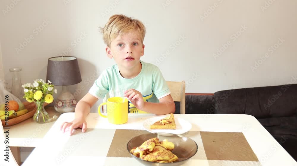 Young Boy Enjoys Tasty Meal at Kitchen Table With Bright Colors and Simple Setting Young Boy Enjoys Tasty Meal at Kitchen Table With Bright Colors and Simple Setting