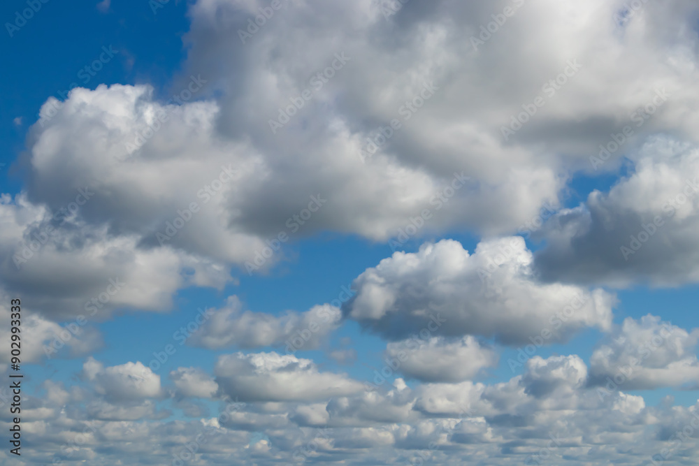 Fluffy clouds drift lazily under a bright blue sky, creating a peaceful and serene atmosphere Fluffy clouds drift lazily under a bright blue sky, creating a peaceful and serene atmosphere