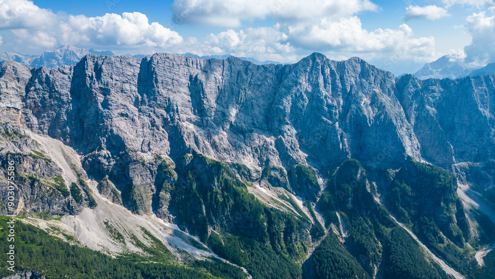 A stunning view of Slemenova Špica, showcasing a picturesque hiking trail in the Slovenian Alps. The image, captured from the air by a drone, highlights the breathtaking landscape, with rugged peaks A stunning view of Slemenova Špica, showcasing a picturesque hiking trail in the Slovenian Alps. The image, captured from the air by a drone, highlights the breathtaking landscape, with rugged peaks