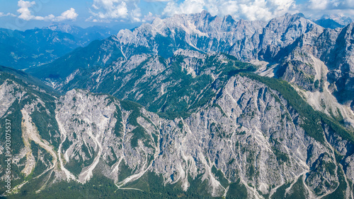 A stunning view of Slemenova Špica, showcasing a picturesque hiking trail in the Slovenian Alps. The image, captured from the air by a drone, highlights the breathtaking landscape, with rugged peaks  photo