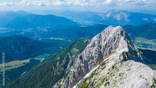 A breathtaking aerial view of Visoka Ponca and Lago di Fusine Superiore in the Italian Alps, captured by a drone. This stunning image showcases the serene lake surrounded by majestic alpine peaks photo