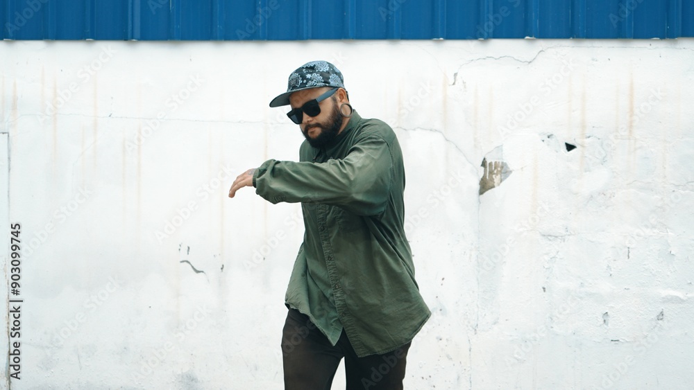 Hipster dancing b-boy foot step at street with blue wall. Asian break dancer practice street dance while stretch arms. Hip hop choreographer perform energetic dance. Outdoor sport 2024. Hiphop. Hipster dancing b-boy foot step at street with blue wall. Asian break dancer practice street dance while stretch arms. Hip hop choreographer perform energetic dance. Outdoor sport 2024. Hiphop.