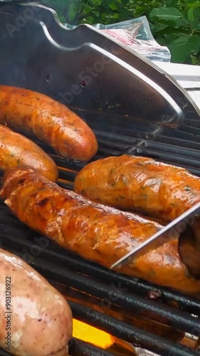 Verrticle - Chef Slicing Juicy Sausages on a Flaming Hot BBQ