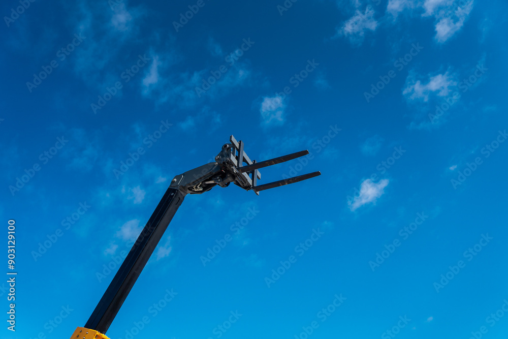 Telescopic lift with forklift raised up in the air for lifting construction project Telescopic lift with forklift raised up in the air for lifting construction project