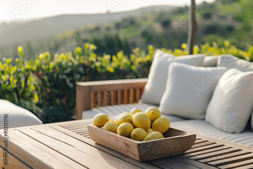 Lounge area with modern furniture, ripe lemons in the wooden plane on the tanle and views of the green hills. photo