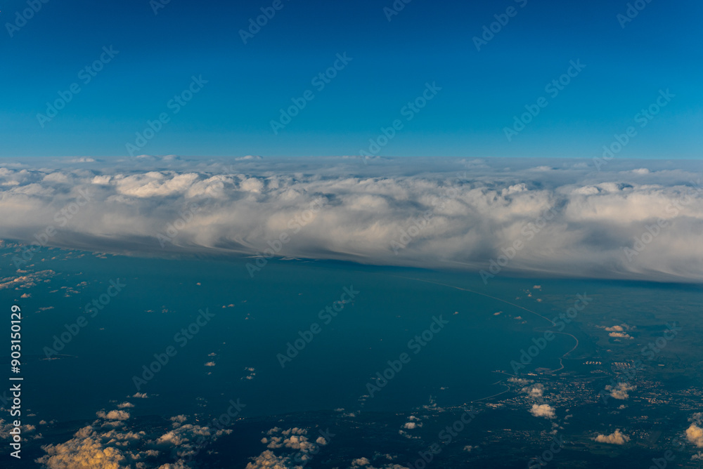 Fototapeta premium White clouds and blue sky. An aerial view of the Sweden from an airplane window.