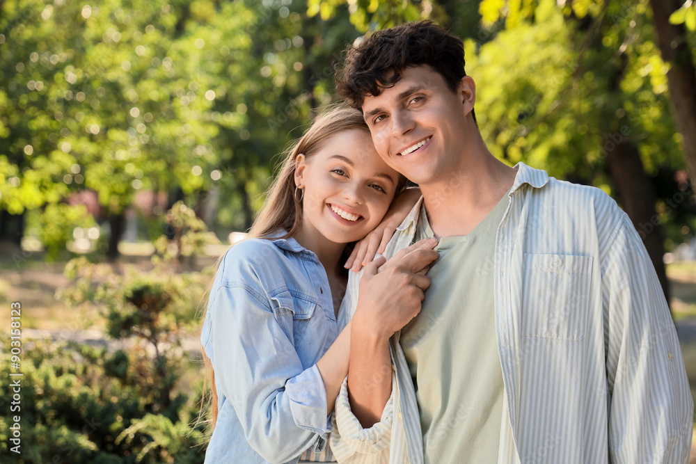 Beautiful young happy couple hugging in summer park Beautiful young happy couple hugging in summer park