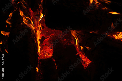 A roaring fire burns brightly in the dark, with dynamic orange and yellow flames that highlight the intense heat and captivating beauty of a blaze.