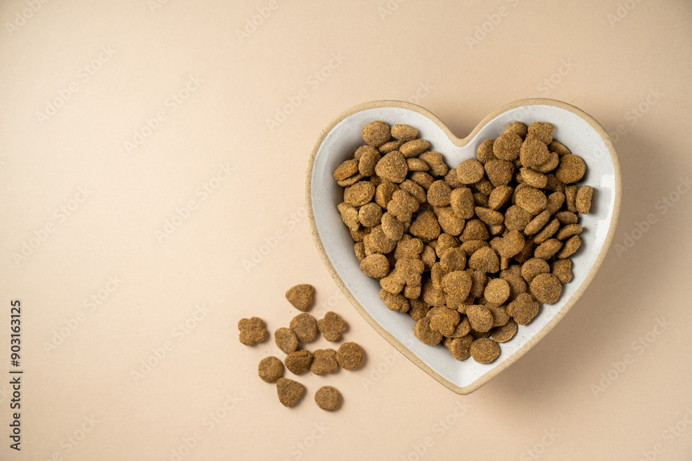 Pet food. Dry cat food in heart shaped bowl. Nutrition for pets, top view. Pet food. Dry cat food in heart shaped bowl. Nutrition for pets, top view.