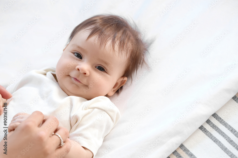 Cute little baby with mother lying on bed, closeup Cute little baby with mother lying on bed, closeup