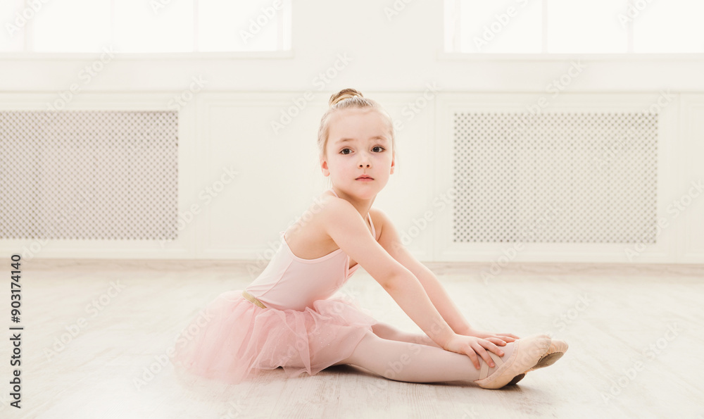 Portrait of little ballerina on floor, copy space. Smiling baby girl dreaming to become professional ballet dancer, classical dance school Portrait of little ballerina on floor, copy space. Smiling baby girl dreaming to become professional ballet dancer, classical dance school