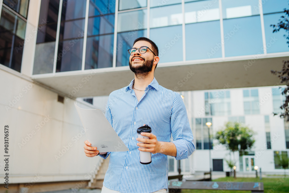 Fototapeta premium Young caucasian businessman going to work to modern business building