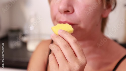 Caucasian Woman Enjoys Freshly Cut Pineapple While Cooking in the Kitchen