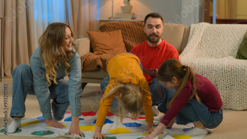 Canvas-taulu Happy family playing funny game twister at home Caucasian parents children play