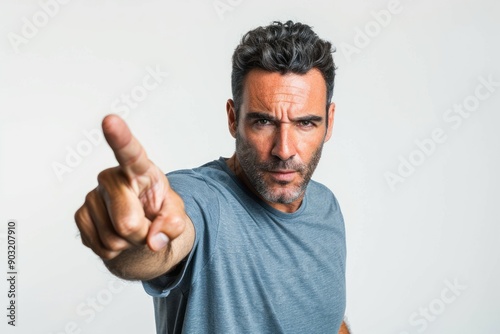 man with angry expression looking at camera and pointing with index finger in accusatory way photo