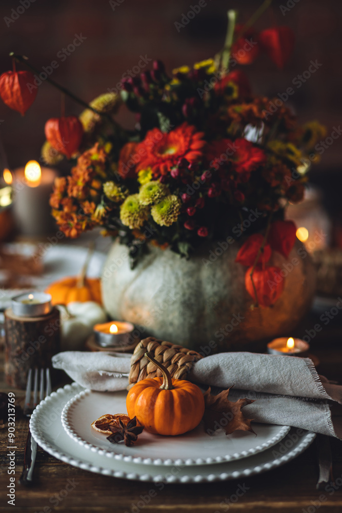 Elegant seasonal fall table setting with floral composition in a pumpkin vase as a centrepiece. White wine, burning candles, romantic cozy atmosphere of family dinner, private autumn wedding Elegant seasonal fall table setting with floral composition in a pumpkin vase as a centrepiece. White wine, burning candles, romantic cozy atmosphere of family dinner, private autumn wedding
