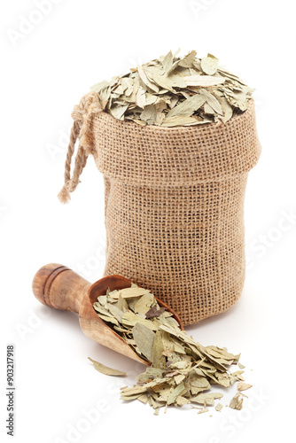 Close-up of Dry Organic Sanay or Senna (Senna alexandrina) leaves, in a jute bag and on a scoop, Isolated on a white background. photo