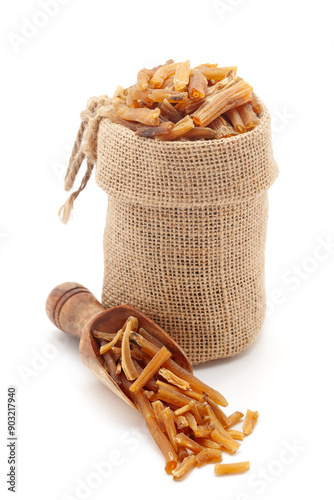 Close-up of Dry Organic Shatavari (Asparagus racemosus) roots, in a jute bag and on a scoop, Isolated on a white background. photo