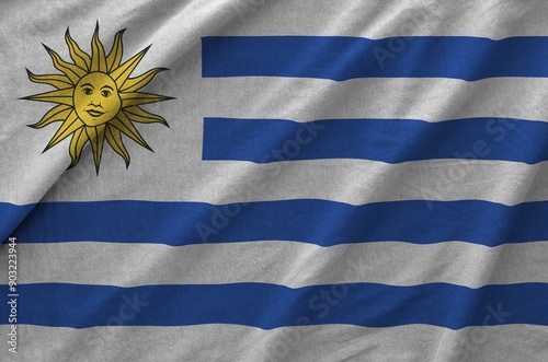 Uruguay flag depicted on folded wavy fabric of old cloth close up photo