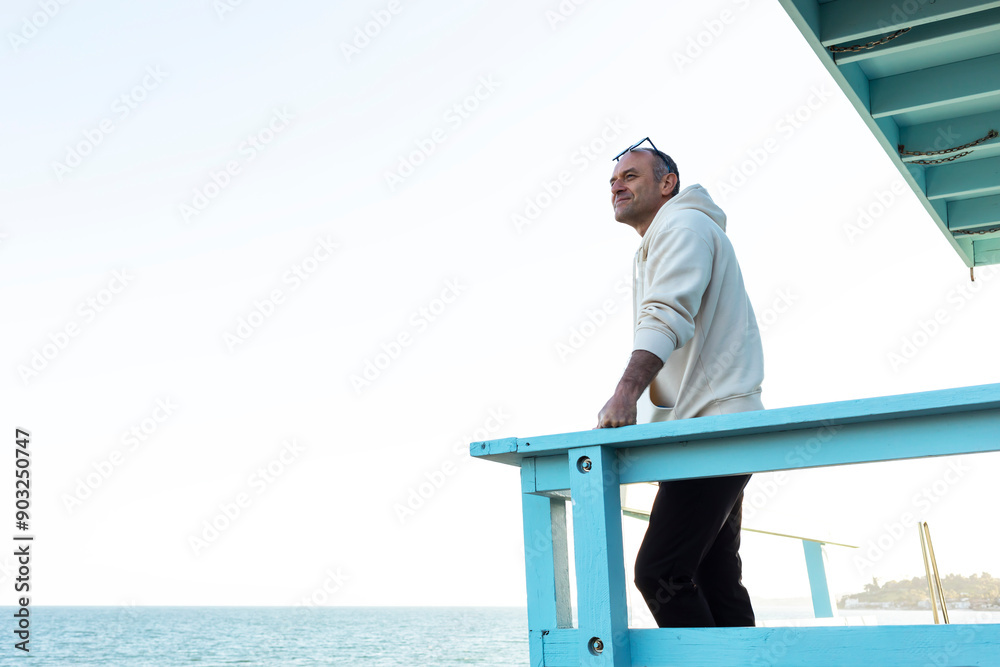 custom made wallpaper toronto digitalMiddle Age Caucasian Man Standing Alone On Wooden Pier And Staring At Sea, Ocean At Sunny Day. Relaxed 40 Yo Male Wears Hoodie, Denim, Sunglasses. Vacation, Trip, Relaxation. Peaceful Atmosphere.