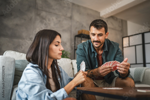 Couple boyfriend and girlfriend play card together at home