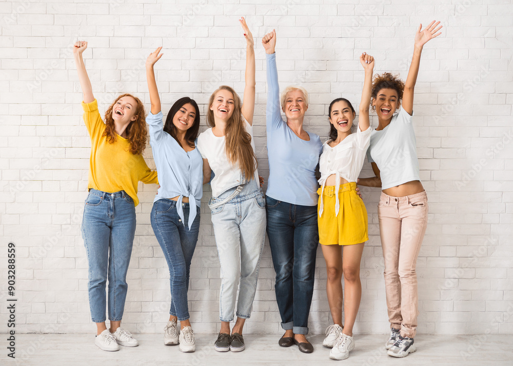 Obraz premium Hello. Diverse Women Waving Hands Smiling At Camera Standing Against White Brick Wall Indoor. Full Length