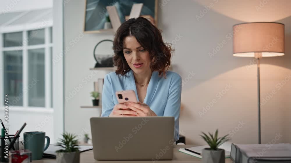 Surprised lady looking smartphone sitting laptop workplace. Happy entrepreneur Surprised lady looking smartphone sitting laptop workplace. Happy entrepreneur
